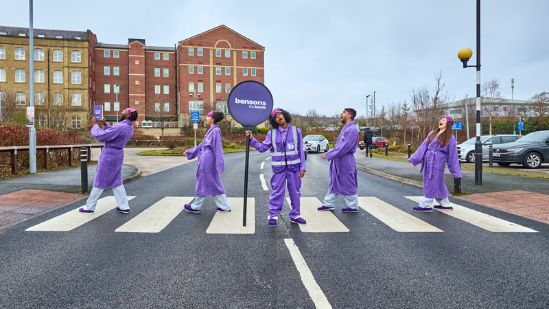 Yawning Bensons commuters as they make their way across a zebra crossing outside the Bensons for Beds Head Office.