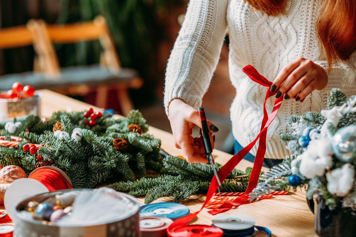 An adult stood at their crafting table working hard on festive creations