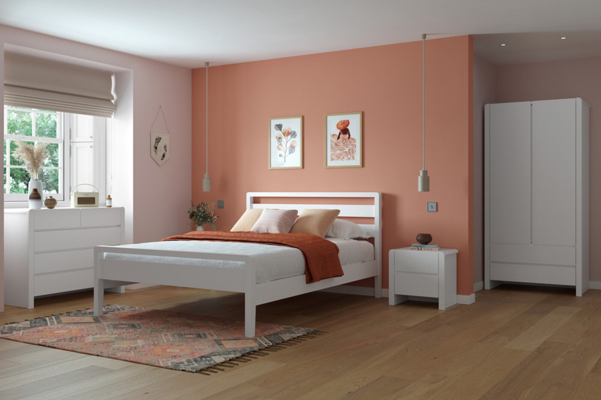 A white double bed frame in a large open bedroom