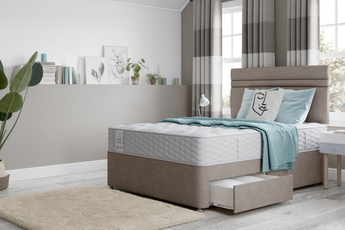A bedroom features a white quilted mattress on an upholstered bed.