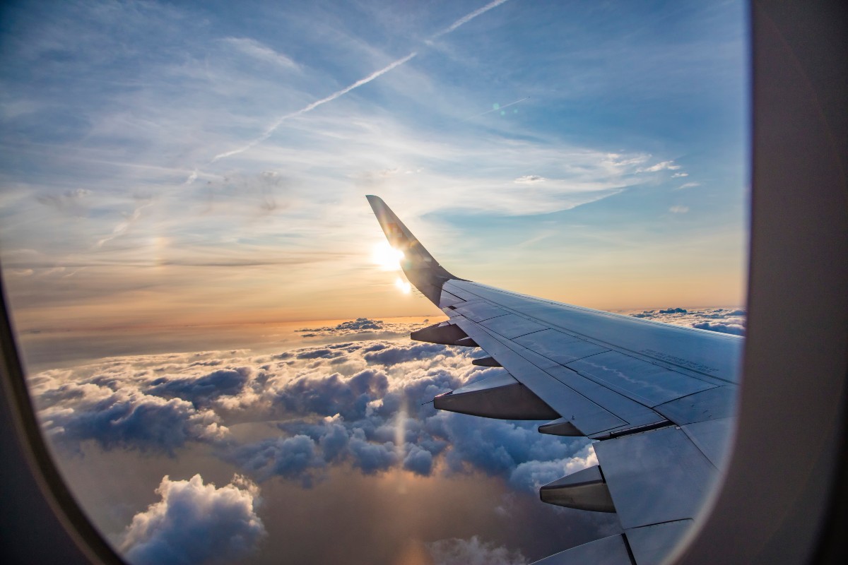 The view from out of a plane's window, the wing of the aeroplane is visible