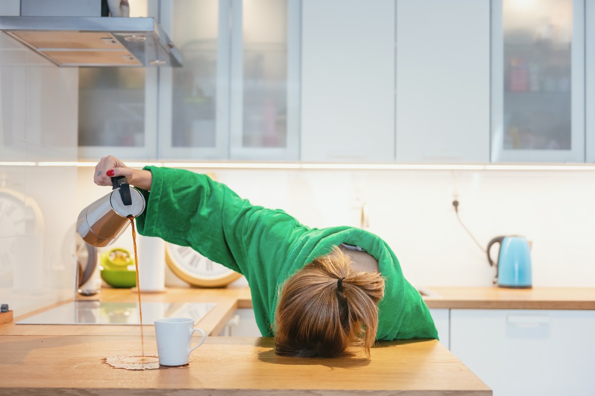 A woman pouring coffee from a cafetiere and missing her cup completely after suffering from a disruptive night's sleep