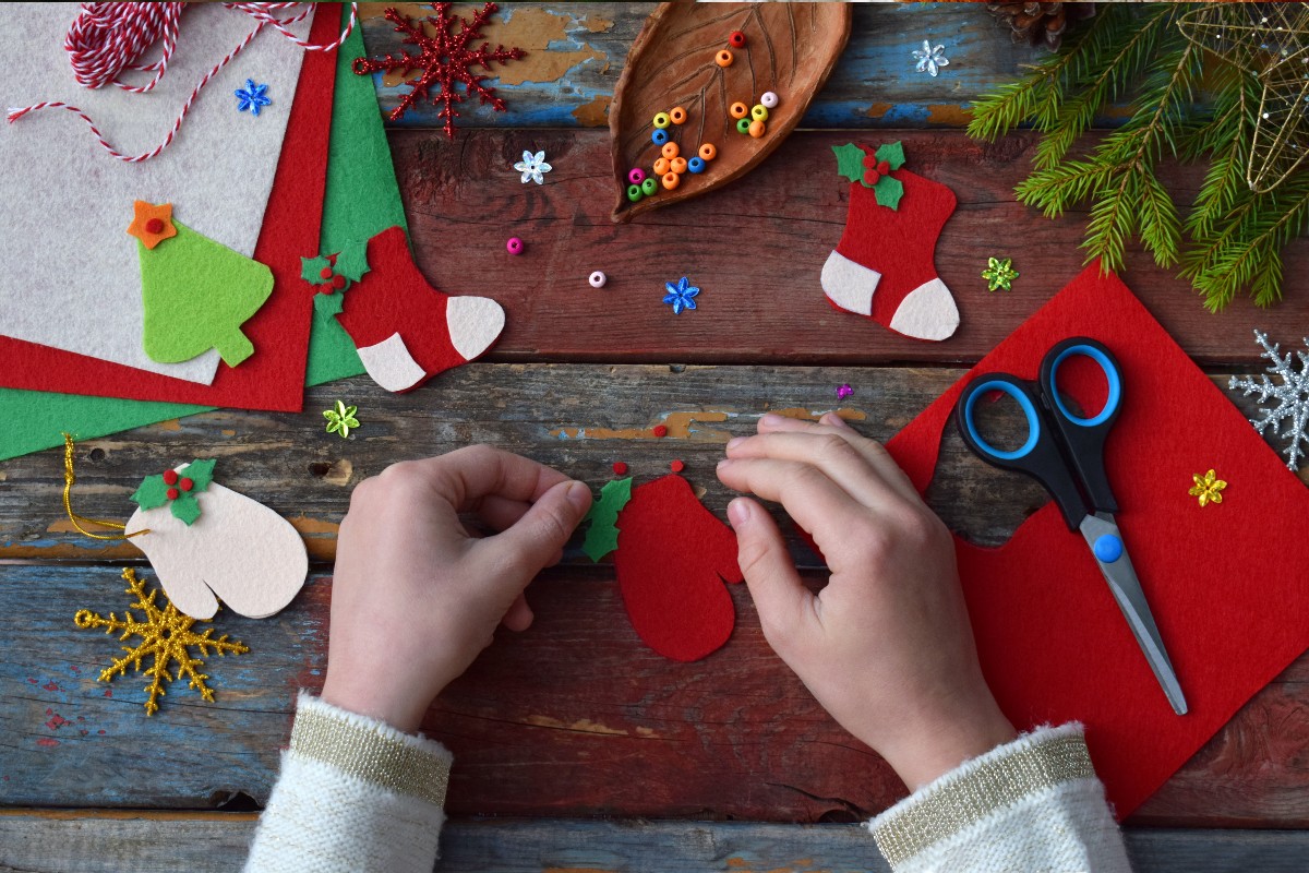 A Christmas crafting station set up complete with 2 busy working hands.