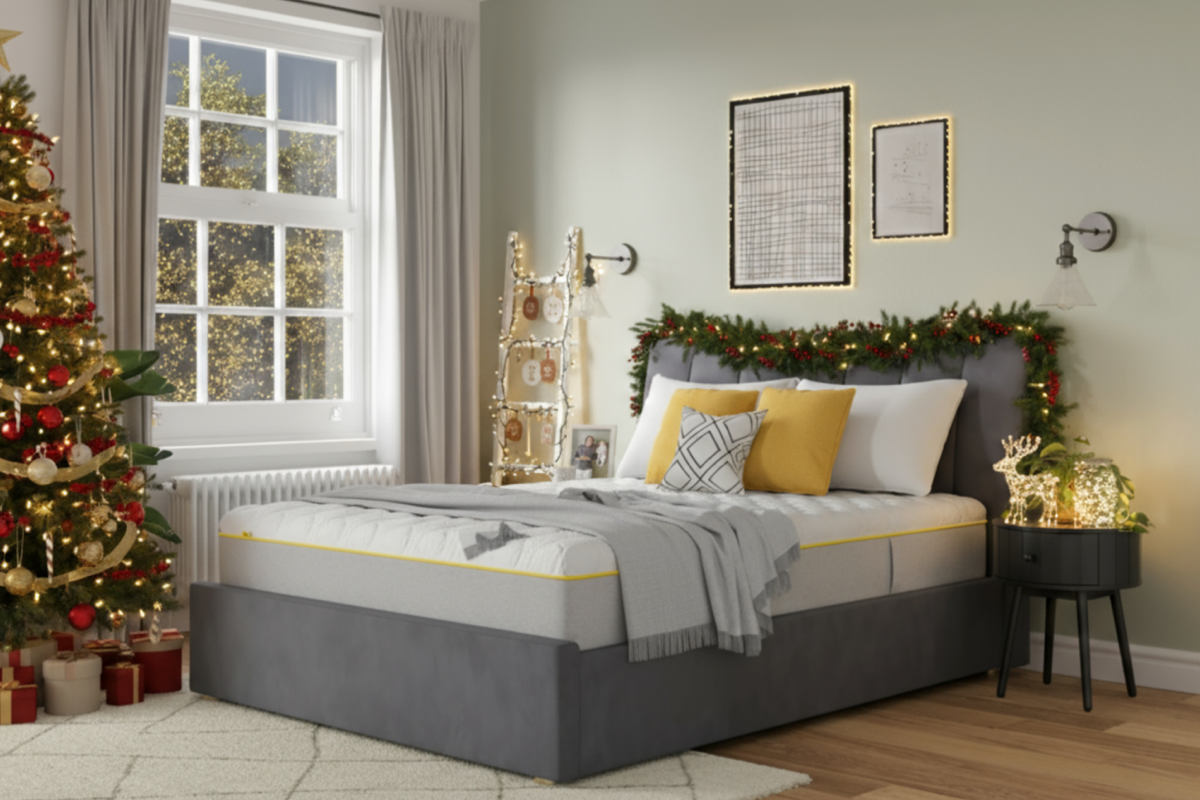 A bedroom lifestyle image adorned with festive decorations including tinsel on the headboard and a decorated Christmas tree at the foot of the bed.