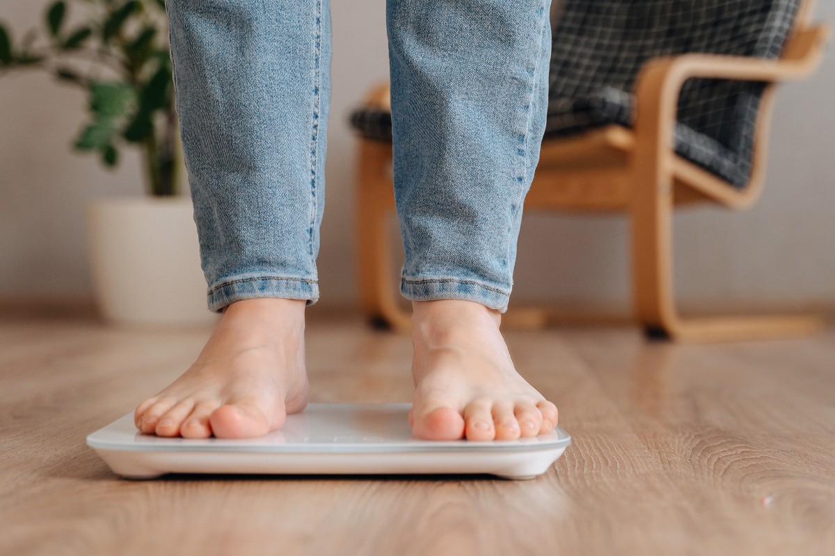 A person standing on a pair of scales to check their weight.