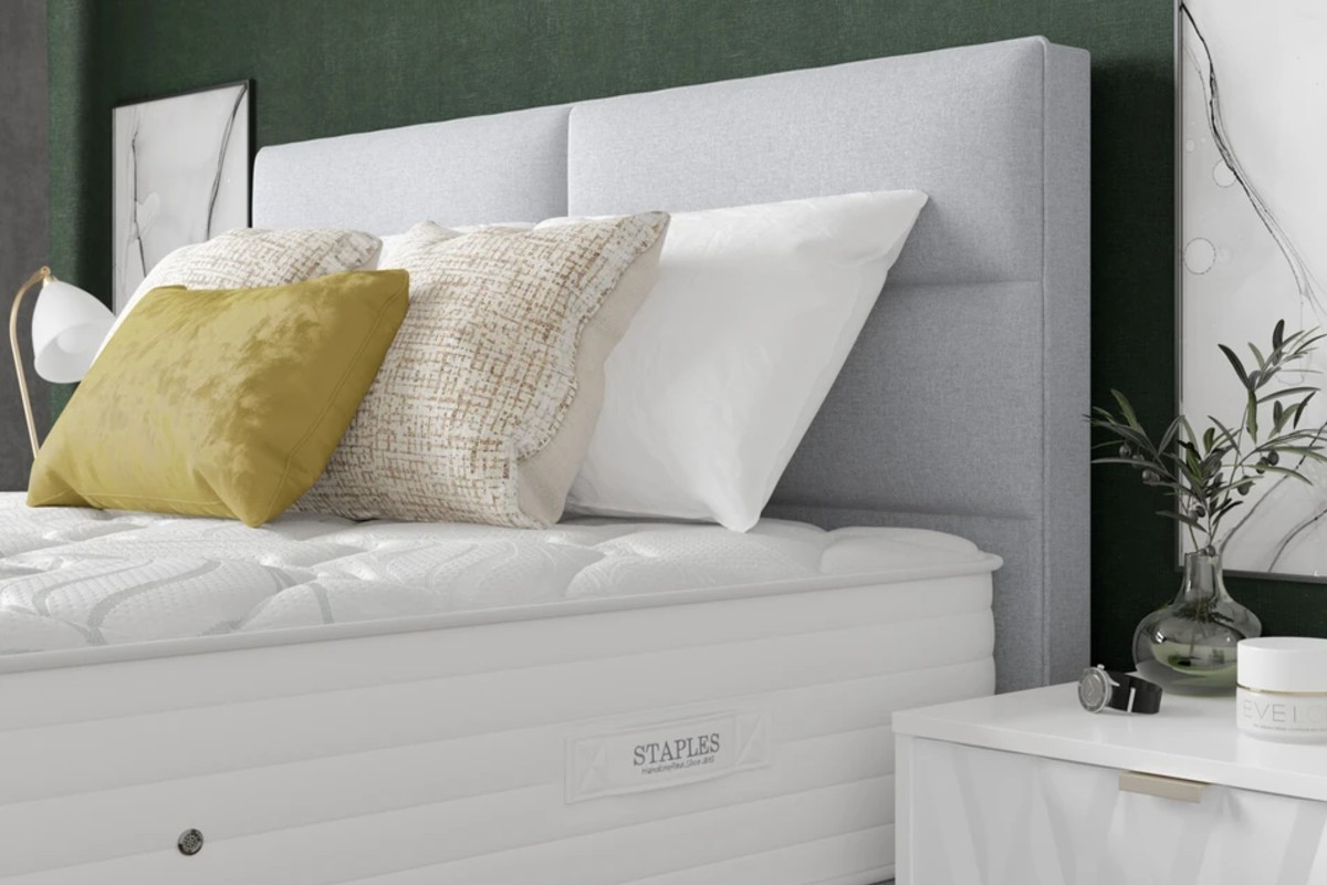 A thick mattress with a quilted top sits on the bed frame