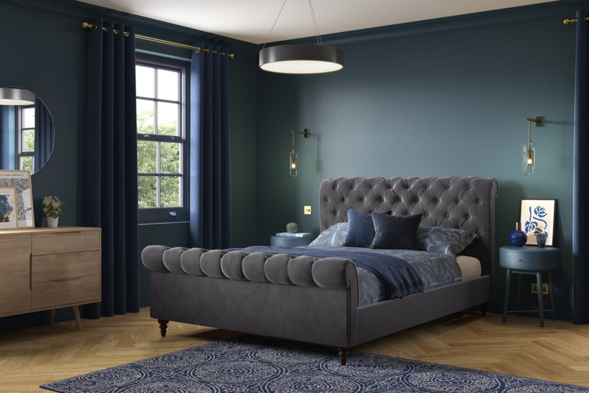 The Penelope sleigh bed with scrolled foot and headboards set in a deep blue bedroom design with wooden floors