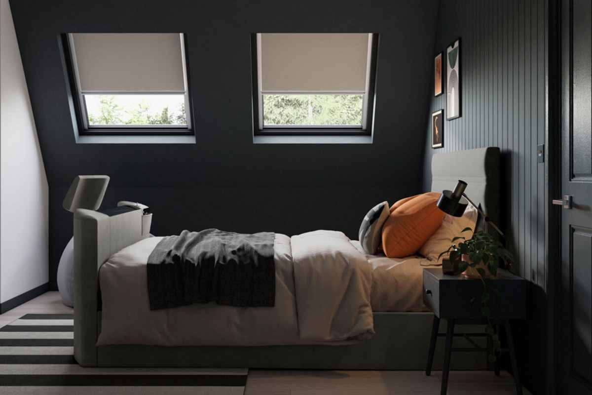 A cosy modern bedroom with dark walls and a neatly made TV bed.