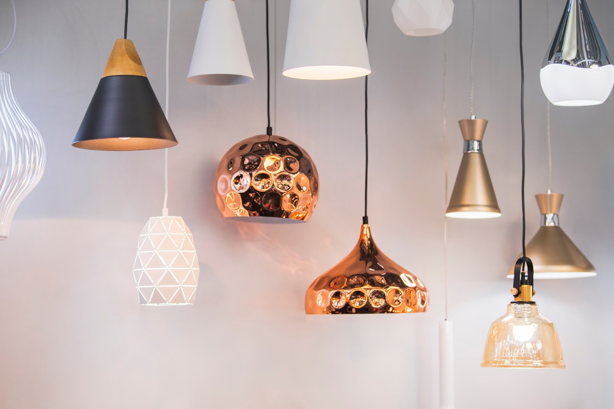 A variety of stylish pendant lights hanging against a neutral coloured wall