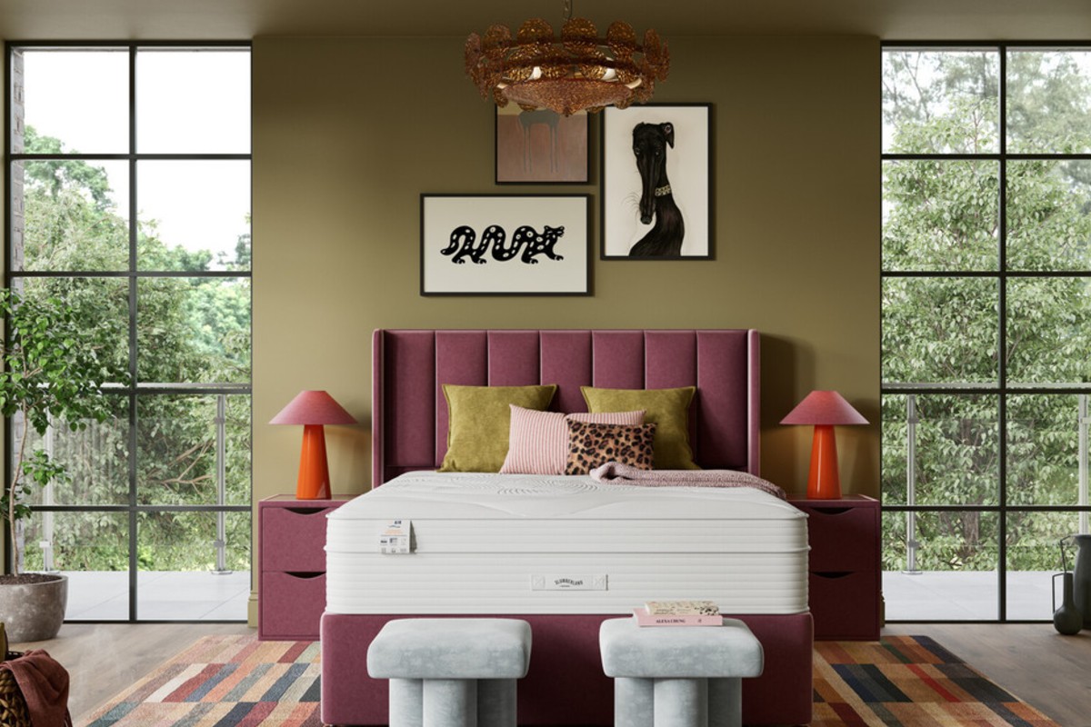 A colourful modern bedroom with a tall plum headboard and a tall mattress.